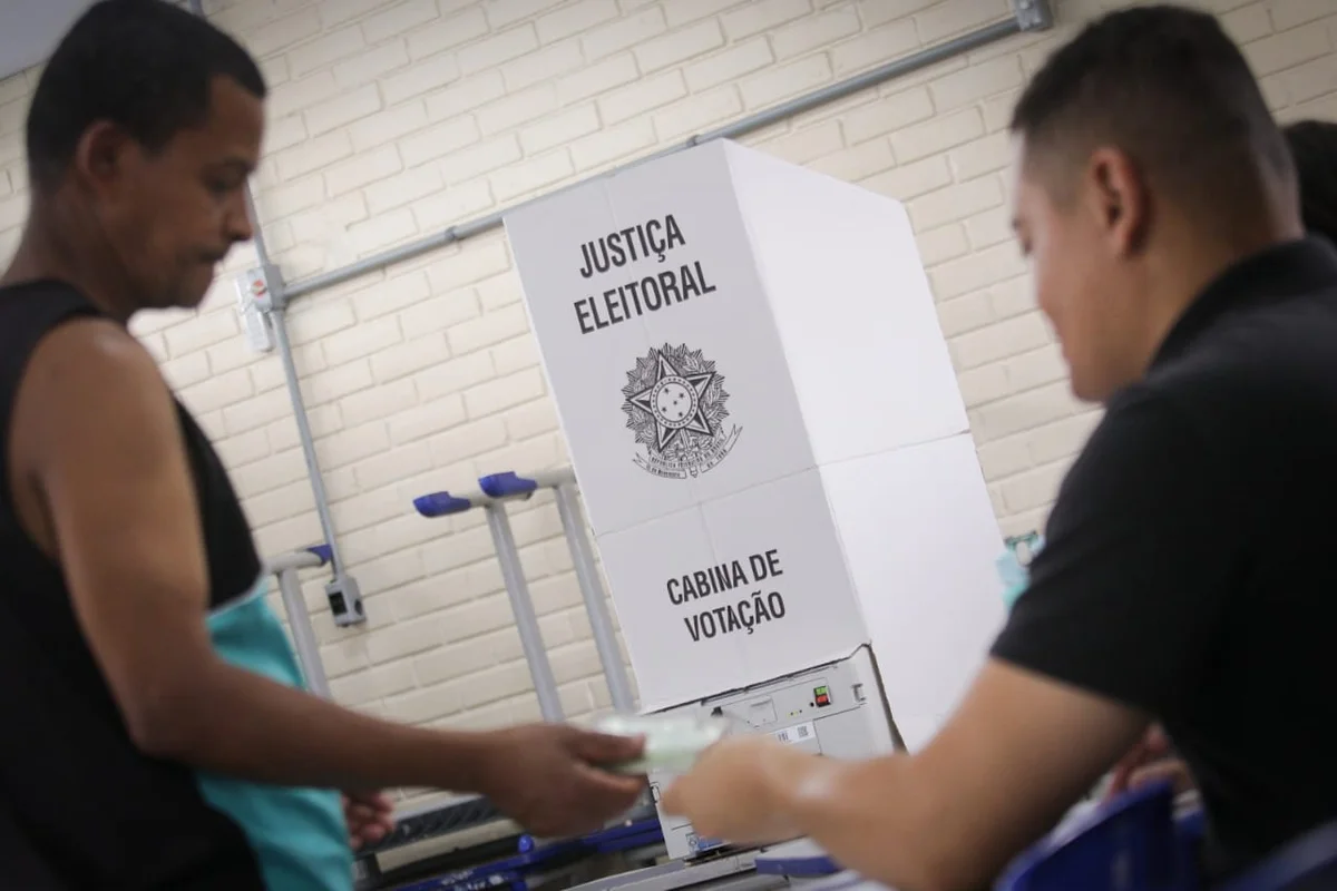 mulher entregando documento em fila de votação