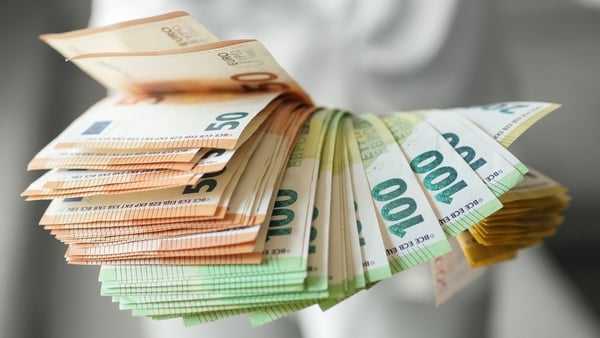Hand holding large fan of euro banknotes in 50, 100, and 200 denominations, concept of abundance, wealth, success and financial prosperity